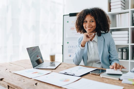 American African business woman using document, computer laptop, calculator, paperwork, documents, in winner and smiling Happy to be successful achievement success. finance and investment concepts.