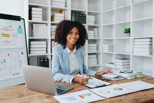 American African business woman using document, computer laptop, calculator, paperwork, documents, in winner and smiling Happy to be successful achievement success. finance and investment concepts.