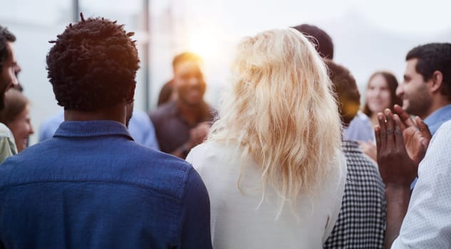 a group of young people stand with their backs looking into the