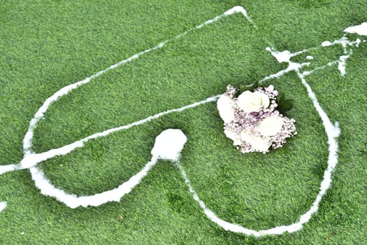 lovers heart symbol is drawn with white foam on green grass, Valentine's Day. High quality photo