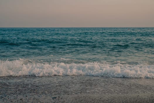 Waves of Mediterranean Sea rolling to the sandy Turkish beach. Beautiful Turkish evening.