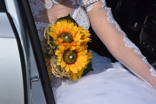 bride in white with a bouquet of yellow sunflower flowers. High quality photo