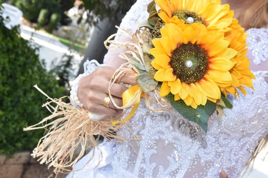 bride in white with a bouquet of yellow sunflower flowers. High quality photo