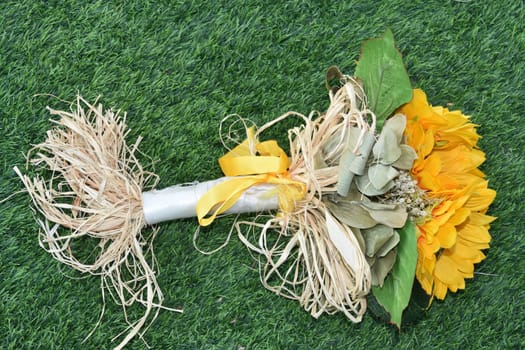 a bouquet of three yellow flowers lies on green grass. High quality photo