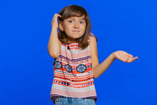 I dont know what to say. Confused young school girl feeling embarrassed about ambiguous question, having doubts, no idea, being clueless and uncertain. Preteen child kid isolated on blue background