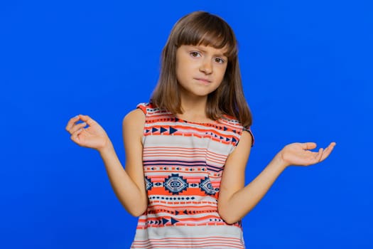What. Why. Young brunette school girl raising hands in indignant expression, asking why, what reason of failure, demonstrating disbelief irritation by troubles. Preteen child kid on blue background