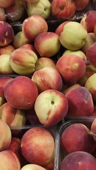 fresh peaches fruits, food in the grocery store, red-yellow background. High quality photo