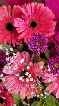 pink gerbera flowers and white lilies in a bouquet, plant shop. High quality photo