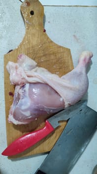 fresh food, chicken leg on kitchen board, cooking knife. High quality photo