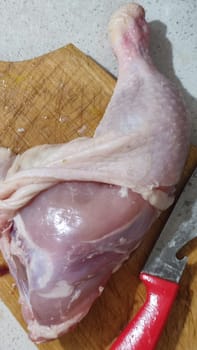 fresh food, chicken leg on kitchen board, cooking knife. High quality photo