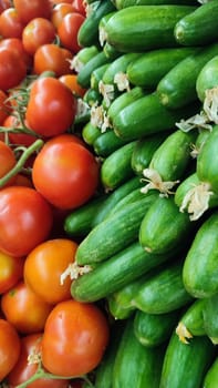 tomatoes and green cucumbers fresh vegetables lie in the grocery store, fresh food, vegetarianism. High quality photo