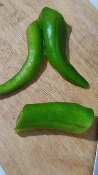 green fresh hot peppers on a kitchen board, a hatchet for cutting vegetables, food. High quality photo
