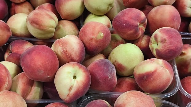 fresh peaches fruits, food in the grocery store, red-yellow background. High quality photo
