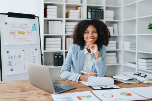 American African business woman using document, computer laptop, calculator, paperwork, documents, in winner and smiling Happy to be successful achievement success. finance and investment concepts.