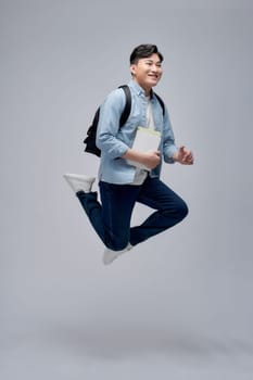 Young student man holding books celebrating a victory or success