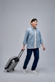 Happy young Asian tourist man holding baggage going to travel on holidays