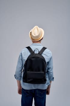 Young traveler wearing a hat with backpack on white background