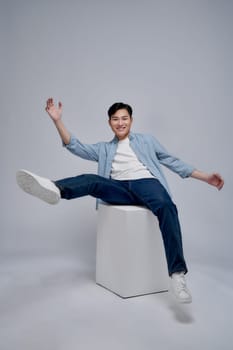 Young Asian man sitting on background