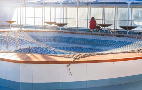 A lonely man in red relaxing at the table of a cruise ship - travel and vacation concept.