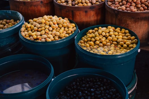 Different olives sale in the traditional farm Turkish market, a counter filled with fresh fruits