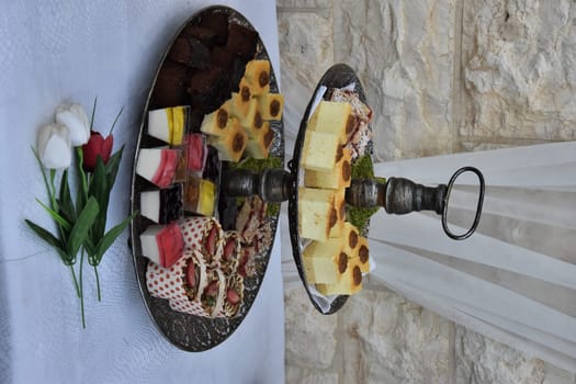 festive dessert on dishes, table with white tablecloth against the wall. High quality photo