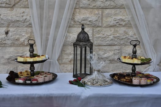 festive dessert on dishes, table with white tablecloth against the wall. High quality photo