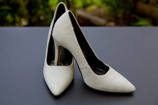 Women's shoes of the bride on table. Selective focus.