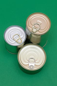 A Group of Stacked Tin Cans with Blank Edges on Green Background. Canned Food. Different Aluminum Cans for Safe and Long Term Storage of Food. Steel Sealed Food Storage Containers