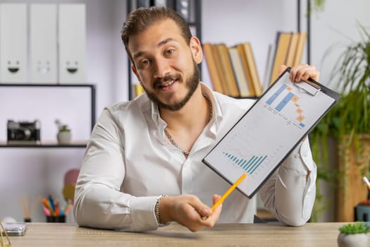 POV of businessman working on laptop at office desk talk on online communication video call with employee boss shows graphical analytics. Freelancer man support services looking at camera. Webcam view