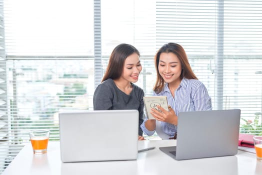 business, teamwork and people concept - female team or businesswomen with laptop computer working at office