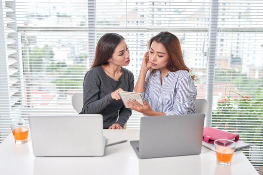 Happy young businesswoman talking to her colleague