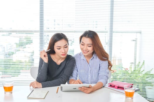 business, teamwork and people concept - female team or businesswomen with laptop computer working at office