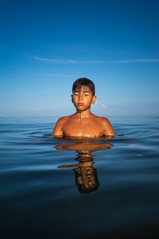 Relaxation and healthy lifestyle. Young boy teenager bathes in the sea.