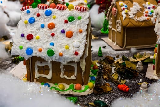 Colorful gingerbread house isolated on blurred background with Christmas decoration.