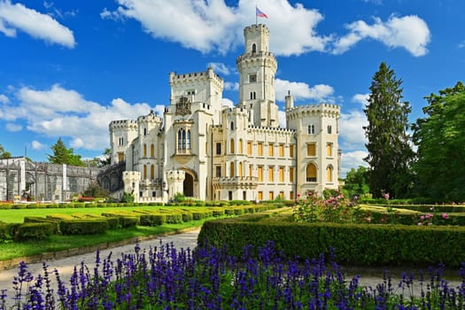 Beautiful old state chateau Hluboká nad Vltavou. View from the outdoor garden in summer with blue sky, sun and clouds.