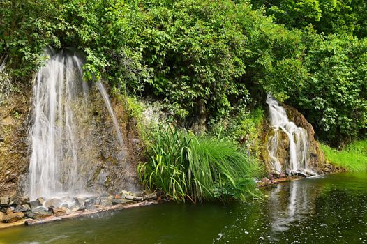 Beautiful small waterfall with a rock in nature. Brno castle Spilberk.