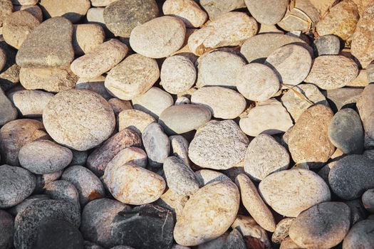 Stone texture closeup of various shapes lying along the coastline