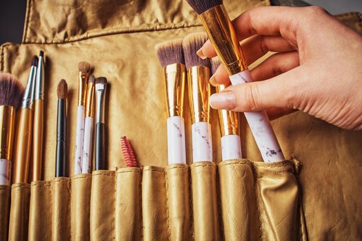 Cosmetic Makeup Brush in female hand on recruitment background.