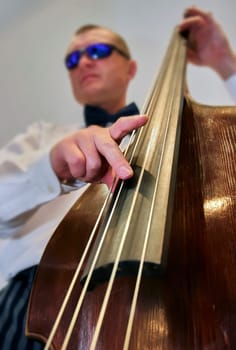 Hands of a musician playing the double bass. Jazz musician performs at a concert.