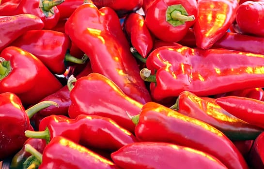 Red chili peppers with vegetables in the market. Tomatoes and peppers are selected by the buyer at the market.