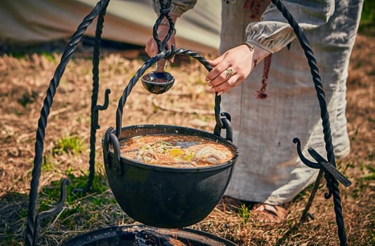 Camping. Soup in a pot over a fire. Stylization under the Middle Ages, vintage.