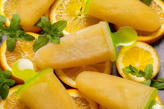 Homemade Orange ice popsicles and orange slices.