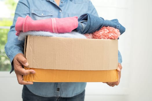 Donation box with used clothes at home to support help for poor people in the world.