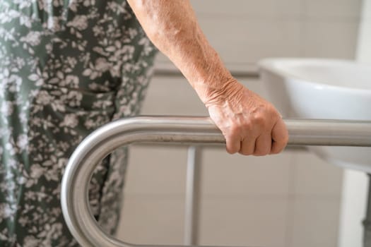 Asian elderly woman patient use toilet bathroom handle security in nursing hospital, healthy strong medical concept.