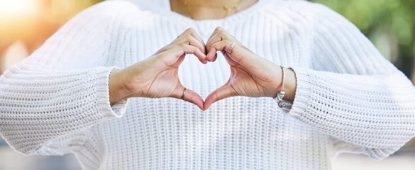 Love, heart and peace with hands of woman in nature for support, motivation and kindness. Thank you, lens flare and hope with closeup of person and sign in outdoors for emoji, health and banner.