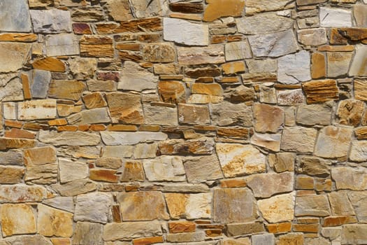 The texture of the old medieval wall of the house, lined with brown stone.