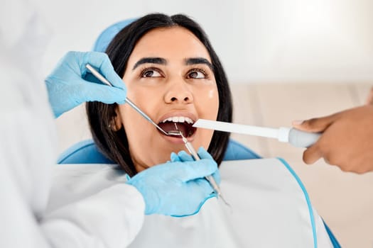 Dentist, woman and patient at a clinic with medical and healthcare for teeth whitening. Mirror, orthodontist and female person with wellness and dental work tool in mouth with care and cleaning.