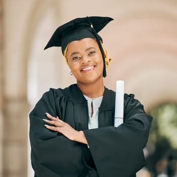 Happy, smile and portrait of woman at graduation with degree, diploma or certificate scroll. Success, education and young African female university graduate with crossed arms for confidence on campus.