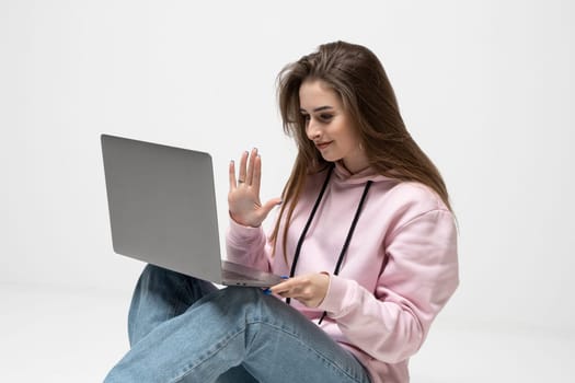Smiling young brunette woman using laptop. Beautiful girl shopping or chatting online in social network, having fun, watching movie, freelancer working on computer project