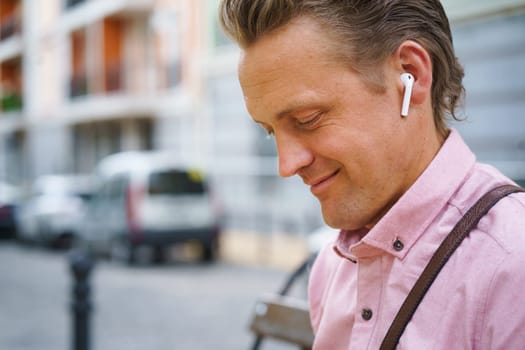 Moment of pure happiness as man with closed eyes enjoys listening to music on bench in bustling urban city. He fully immersed in music, finding relaxation and contentment in melodies. . High quality photo